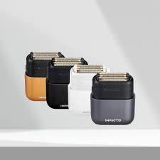 Set of three black electric shavers on a white background